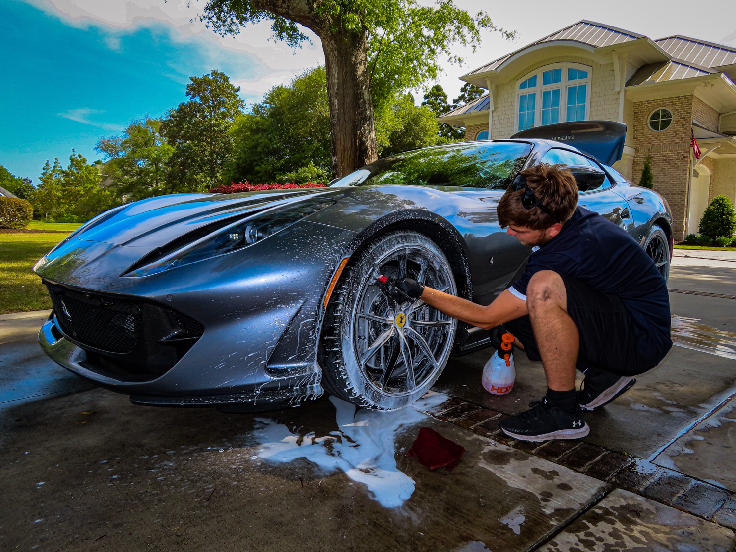 A RevvedPro client hand-washing a luxury sports car
