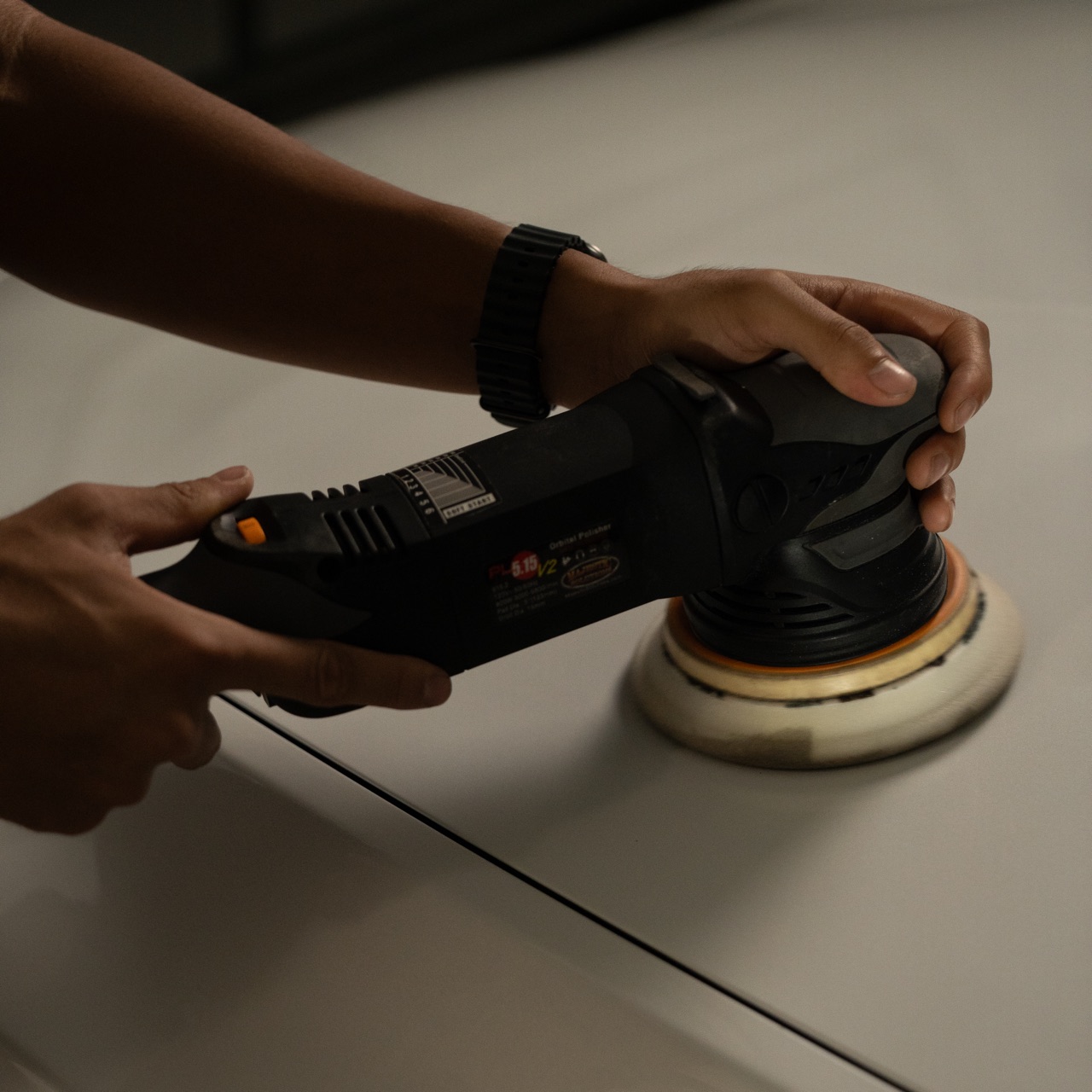Detailer running a polisher for paint correction