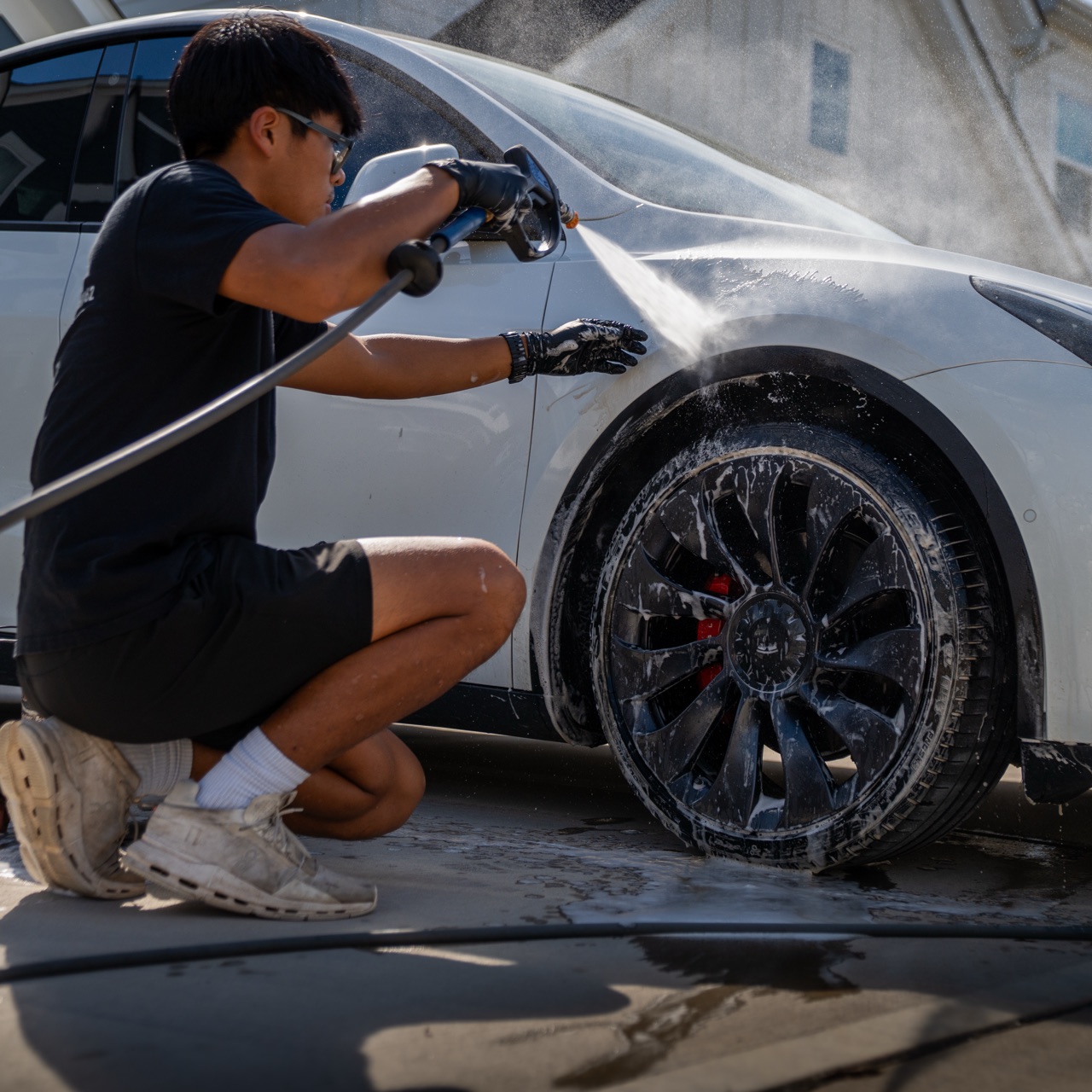 Detailer rinsing a vehicle